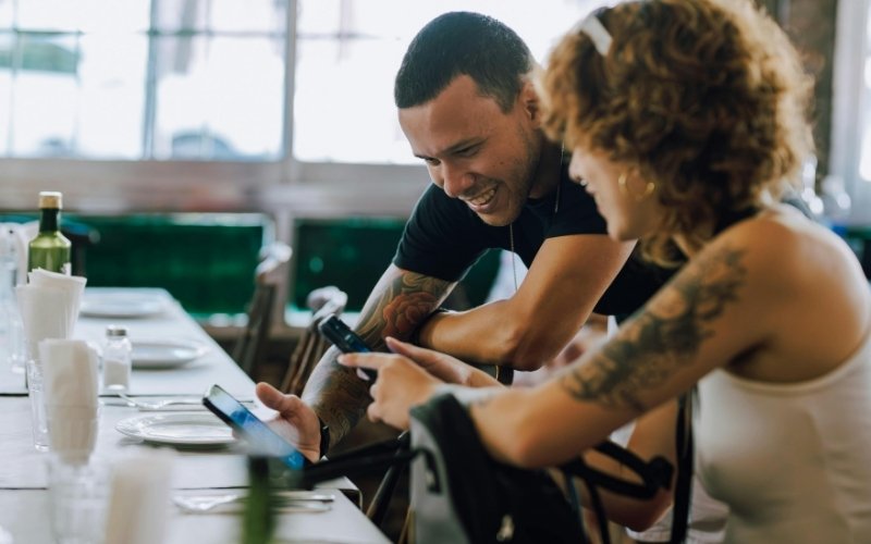 A restaurant owner showing a client something on his phone
